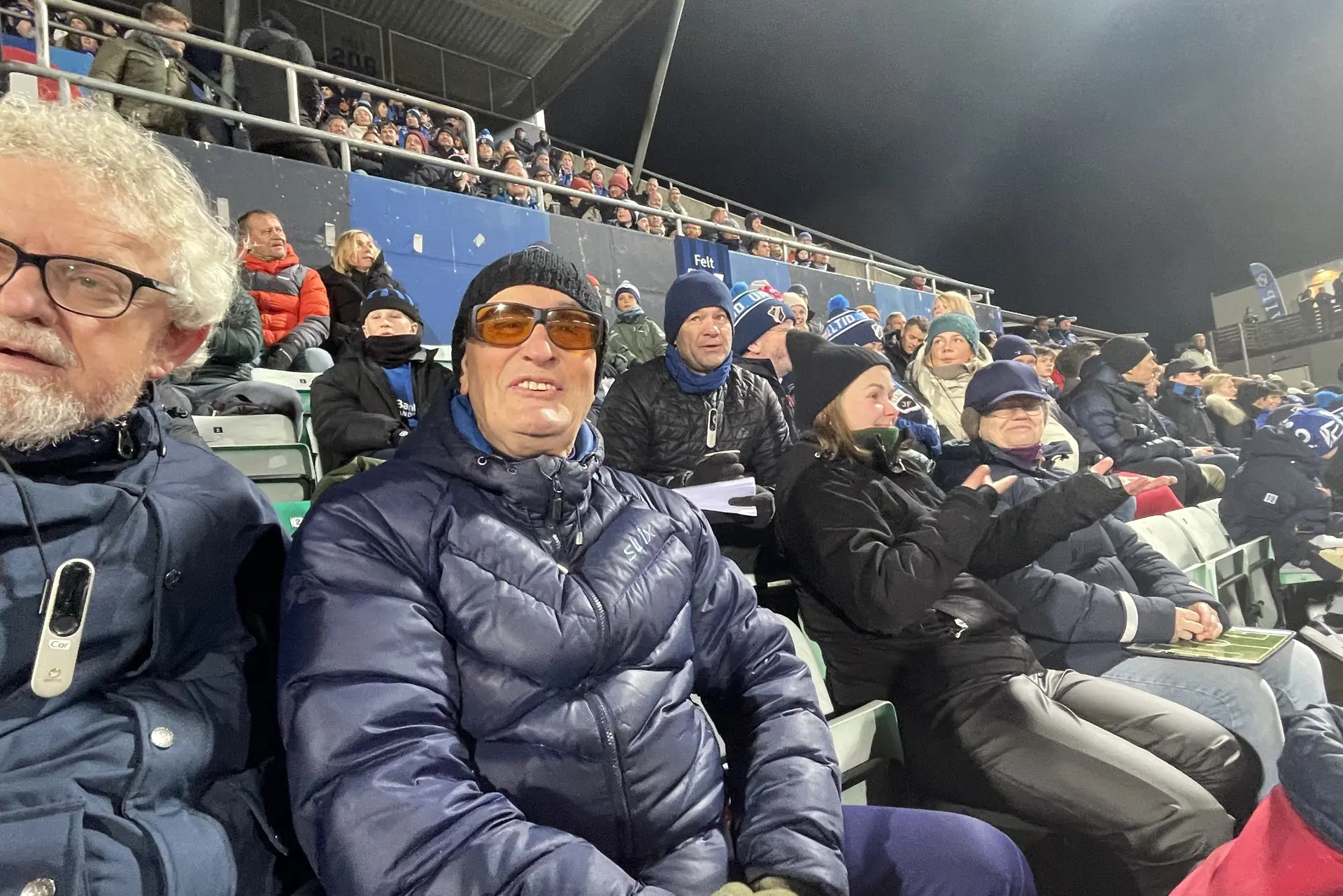 En gruppe mennesker som sitter på en stadionplass