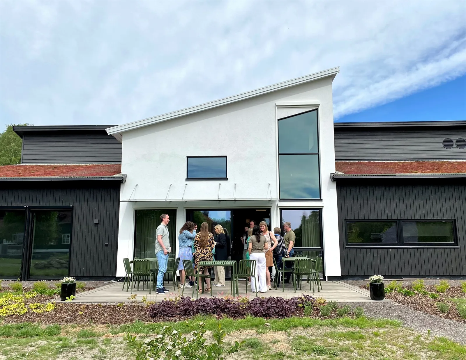 En gruppe mennesker som står utenfor et hus