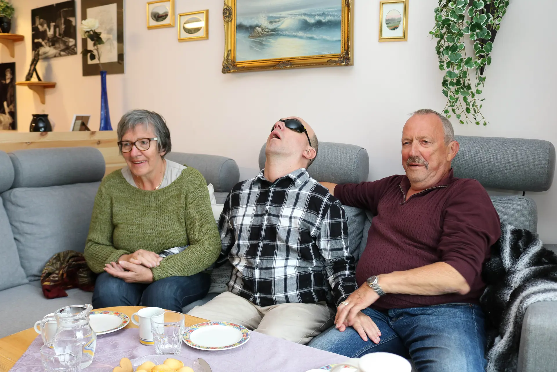 En gruppe mennesker som sitter på en sofa