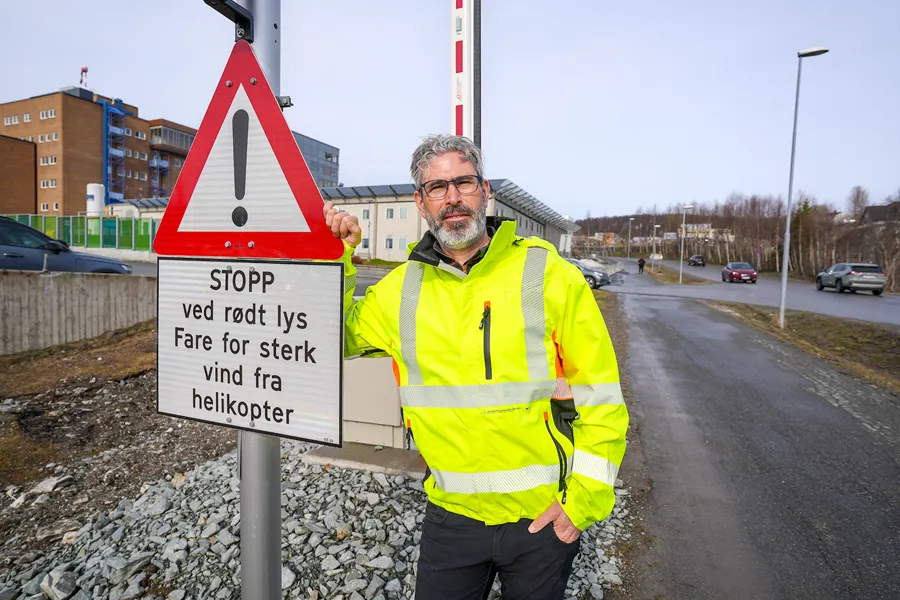 En mann som står ved siden av et skilt