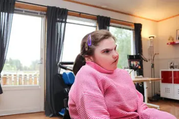 Ung jente som sitter. Hun har rosa genser på seg.